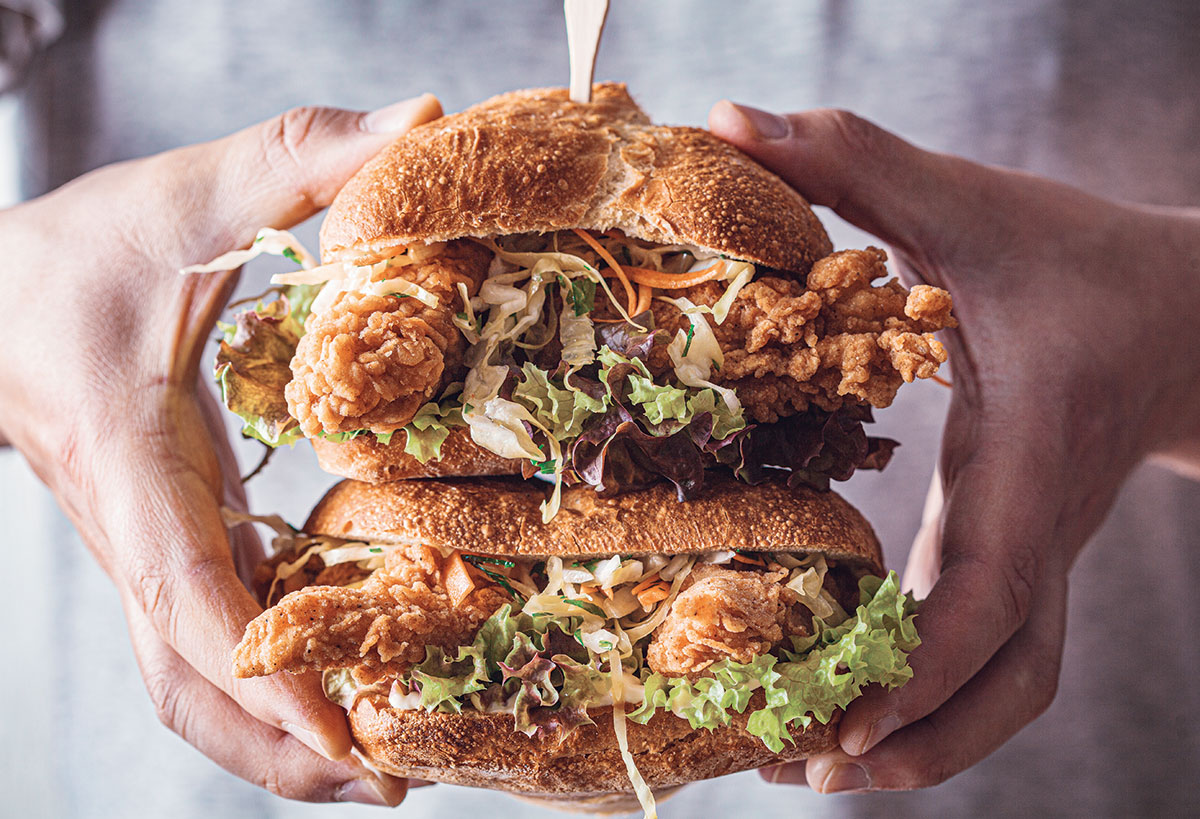 Hands Holding Fried Chicken Sandwiches