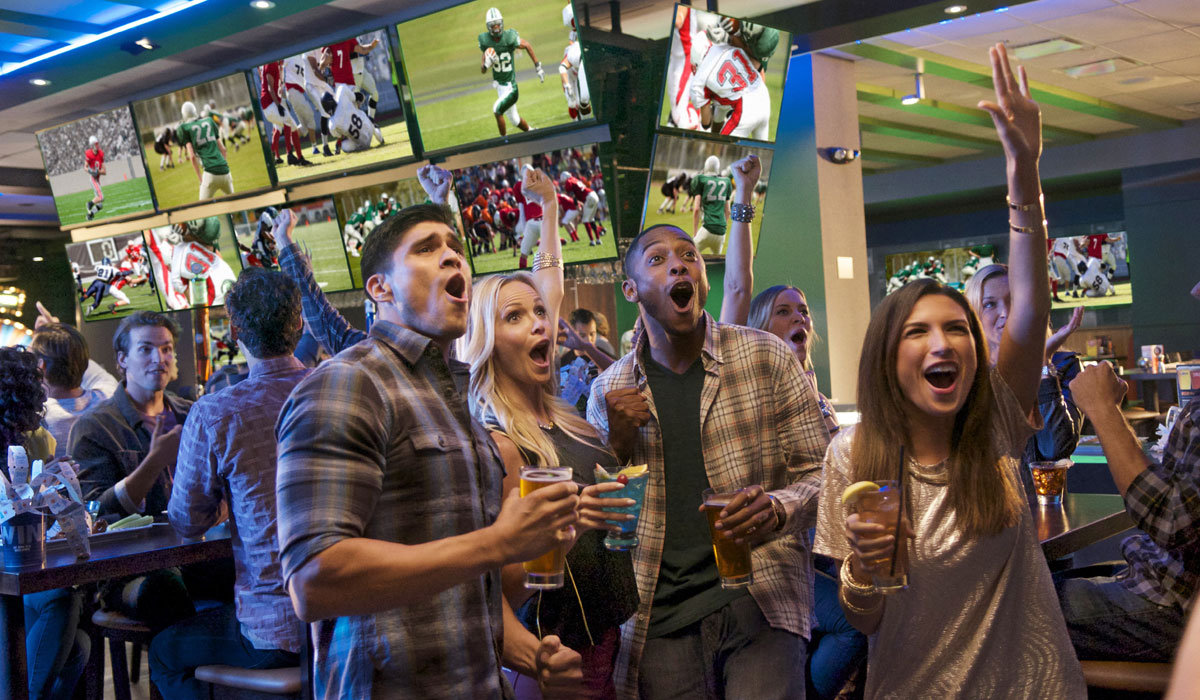 Dave  & Buster's Customers Watch Sports On TV With Drinks In Their Hands