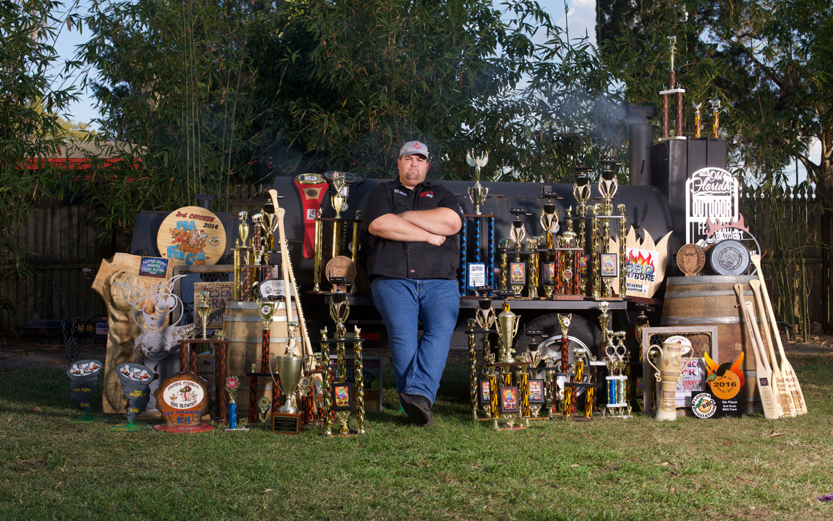 Sonny’s BBQ's Head Pitmaster Bryan Mroczka Stands With All His Trophies