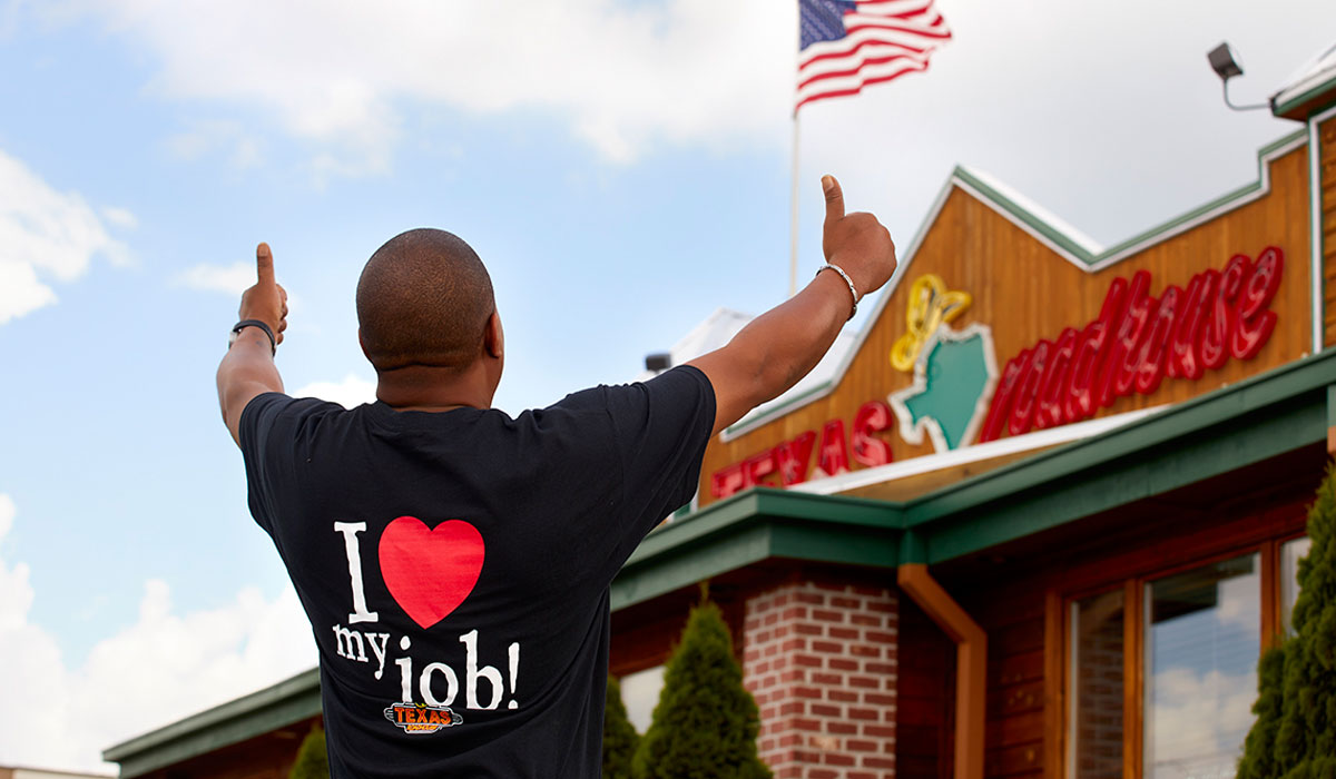 A Texas Roadhouse Employee Gives The Thumbs Up Outside A Restaurant