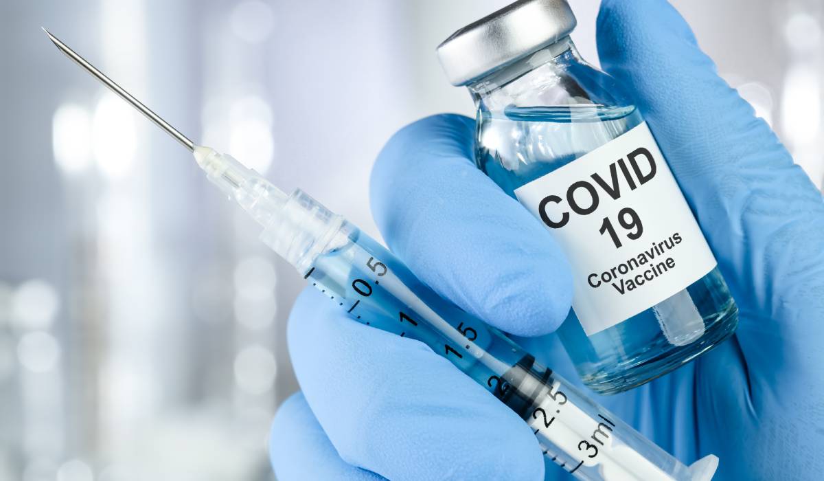 Healthcare Cure Concept With A Hand In Blue Medical Gloves Holding Coronavirus, Covid 19 Virus, Vaccine Vial