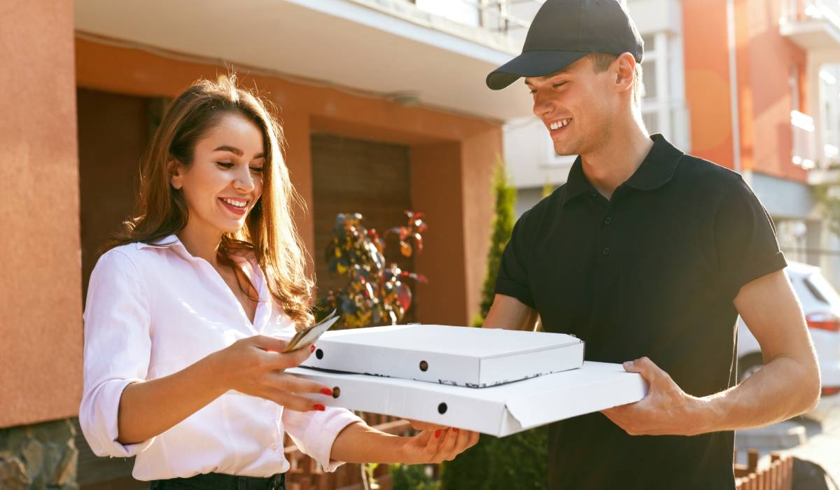 Delivery Driver Giving Food To Woman