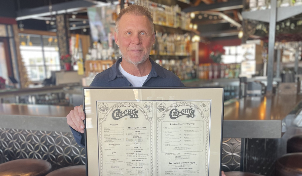 Michael McDermott holding an old Chi-Chi's menu.