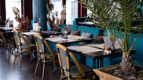 Interior of the restaurant in blue tones. Tables and wicker chairs.