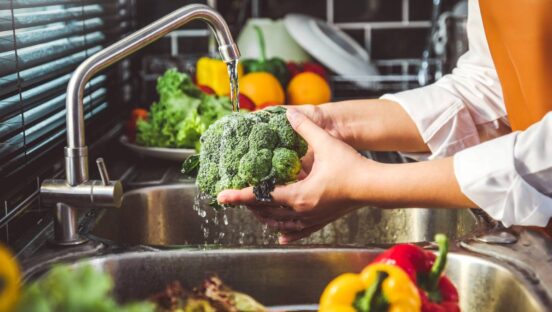 Chef washing vegetables in the sink.
