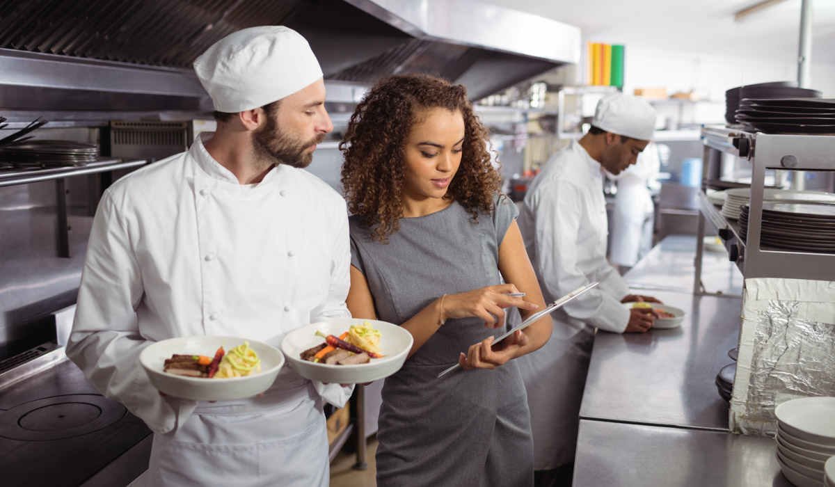 Restaurant manager in kitchen with chef stock image.
