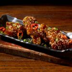 Duck Wings, tossed in teriyaki sauce and topped with toasted sesame seeds, Fresno peppers and scallions.