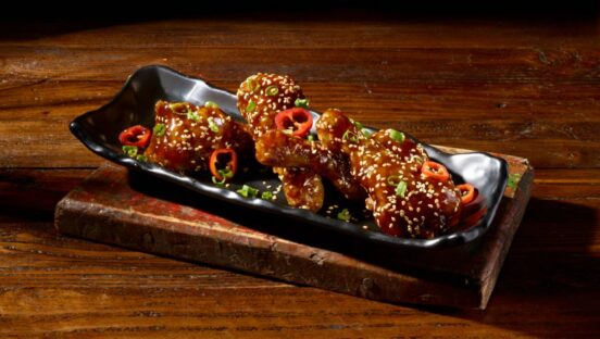 Duck Wings, tossed in teriyaki sauce and topped with toasted sesame seeds, Fresno peppers and scallions.